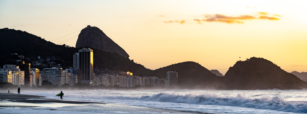 Quais são os bairros mais seguros do Rio de Janeiro? 2 copacabana beach rio de janeiro with sugarloaf mountain sunset